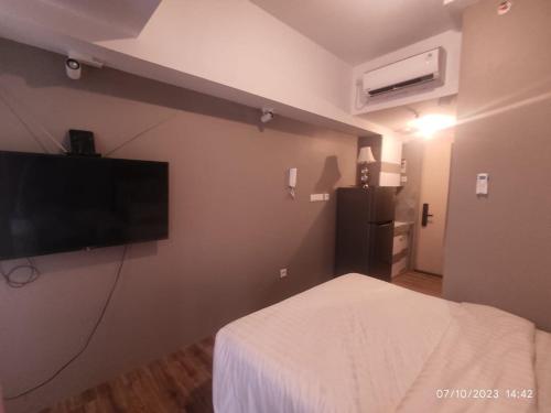 a hotel room with a bed and a flat screen tv at Apartemen Tokyo Riverside PIK2 tower Chikusei 