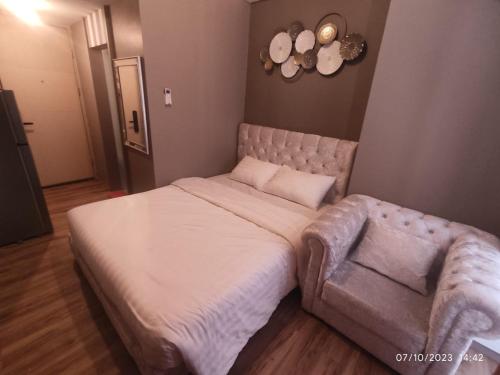 a bedroom with a large bed and a couch at Apartemen Tokyo Riverside PIK2 tower Chikusei 