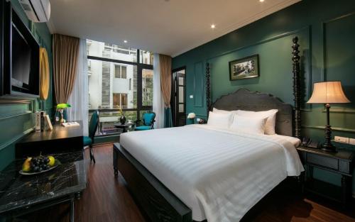 1 dormitorio con 1 cama blanca grande y paredes verdes en Grande Collection Hotel & Spa, en Hanói