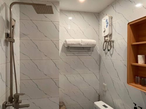 金邊的住宿－ARK House，一间带白色大理石墙壁和毛巾分配器的浴室