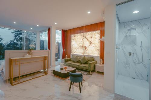 a bathroom with a shower and a couch and a sink at Villa Cella Bella Ubud in Ubud