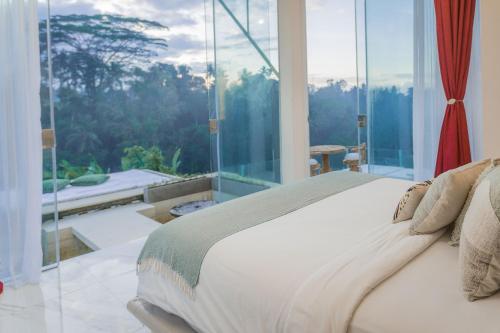 a bedroom with a bed and a large glass window at Villa Cella Bella Ubud in Ubud