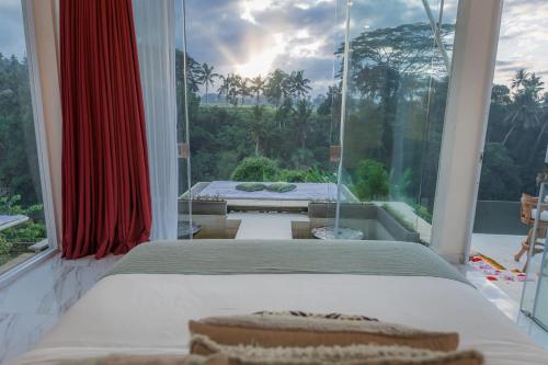 a bedroom with a bed and a large window at Villa Cella Bella Ubud in Ubud