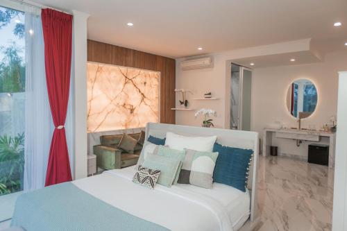 a bedroom with a bed with blue and white pillows at Villa Cella Bella Ubud in Ubud