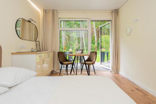 a bedroom with a bed and a table and chairs at Seaside apartments 2 in Palanga