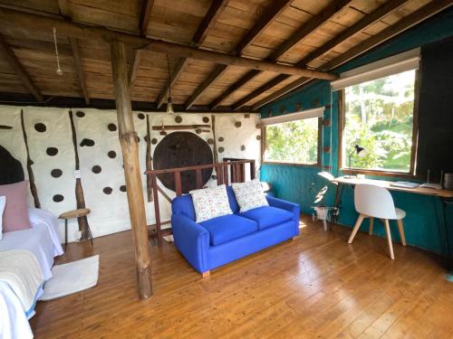 a bedroom with a blue couch in a room at El bosque de las hadas II (Cabaña Magic House) in Santa Elena