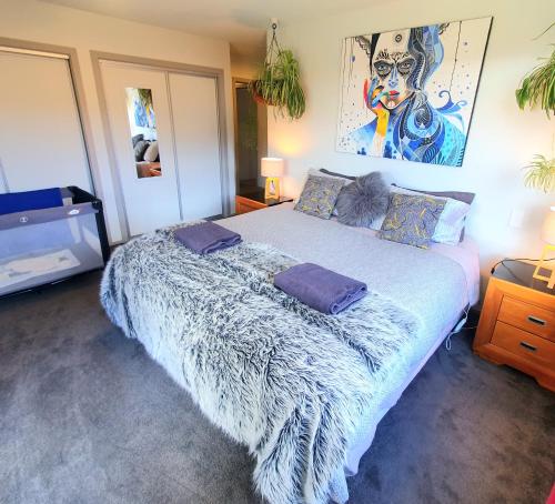 um quarto com uma cama grande com almofadas em Hawea Heaven: Superking beds + Hot Tub + Mountain em Wanaka