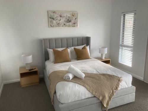 a bedroom with a large white bed with two lamps at Kincaid@234 in Wagga Wagga