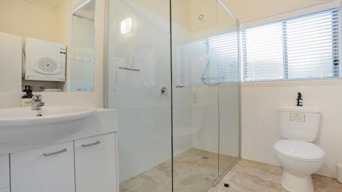 La salle de bains est pourvue de toilettes, d'un lavabo et d'une douche. dans l'établissement Paradise Court 6, Tura Beach, à Tura Beach