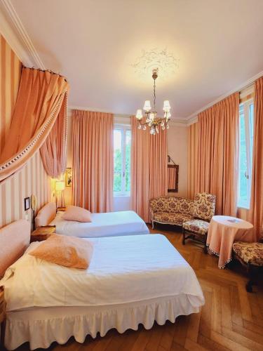 a hotel room with two beds and a couch at Hôtel Le Manoir in Barr
