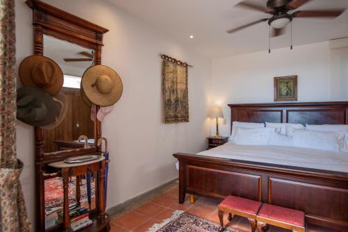 um quarto com uma grande cama de madeira e uma ventoinha em LA SUNSET CONDO em San Miguel de Allende