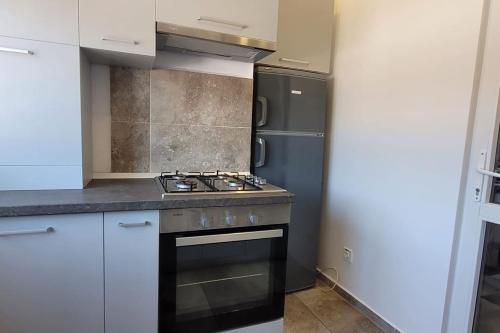 a kitchen with a stove and a refrigerator at Elysian Urbanscape BLUE, near Bucharest in Roşu