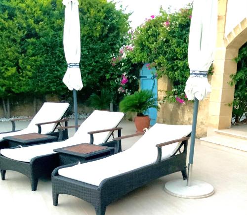 a group of chairs with umbrellas on a patio at Casa Santos Kyrenia in Kérynia