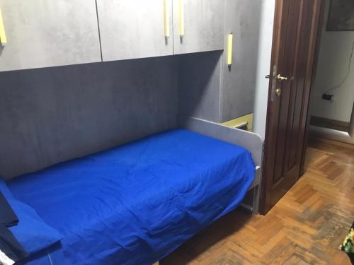 a bed with a blue blanket in a room at Dan House in Montefiascone
