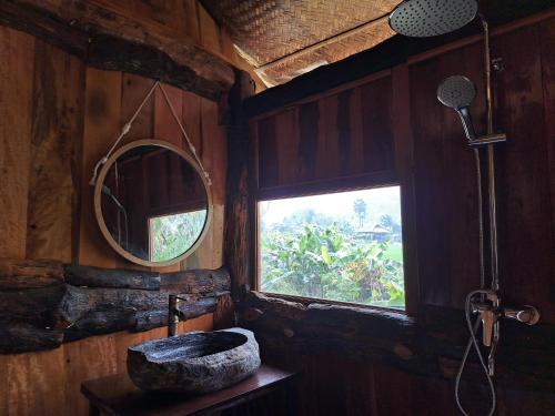 uma casa de banho com um lavatório de pedra e um espelho. em Xoi Farmstay - Homefarm in Lam Thuong valley em Lung Co (1)