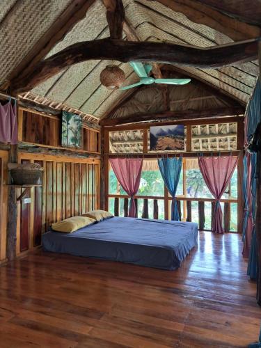 uma cama num quarto numa casa de madeira em Xoi Farmstay - Homefarm in Lam Thuong valley em Lung Co (1)