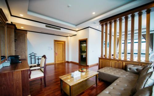 sala de estar con sofá y mesa en Sisombat Plaza Hotel, en Vang Vieng