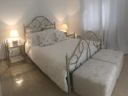 a bedroom with a white bed with two tables and two lamps at Casa Santos Kyrenia in Kérynia