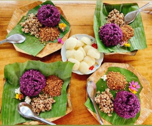 uma mesa com três pratos de comida em folhas em Xoi Farmstay - Homefarm in Lam Thuong valley em Lung Co (1)