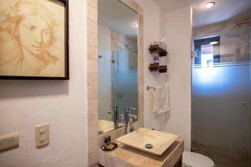 uma casa de banho com um lavatório, um WC e um espelho. em LA SUNSET CONDO em San Miguel de Allende