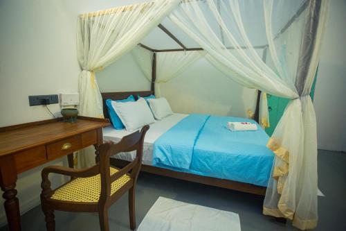a bedroom with a bed and a desk and a chair at Villa Beach Zone in Talpe