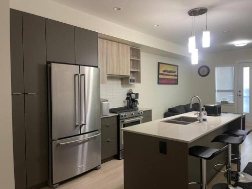 a kitchen with a stainless steel refrigerator and an island at Modern 3Bed-2.5Bath - Delta, BC in Delta