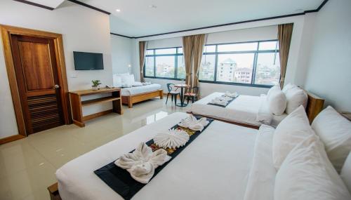 a hotel room with two beds and a living room at Sisombat Plaza Hotel in Vang Vieng