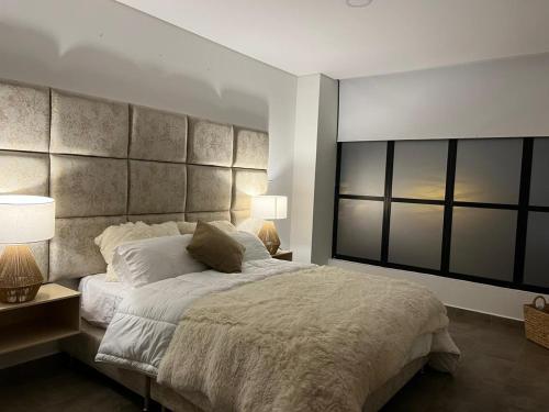 a bedroom with a large bed and two lamps at Levits in Medellín