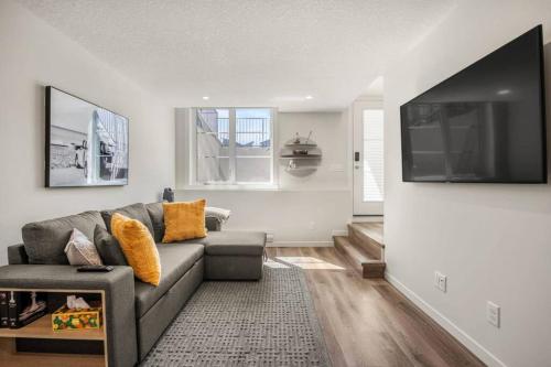 a living room with a couch and a flat screen tv at Rockland Oasis: 1BR + Parking in Calgary