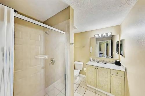 a bathroom with a shower and a toilet and a sink at Entire Rental 3-BR Minutes from Disney x8 Hot tub in Orlando
