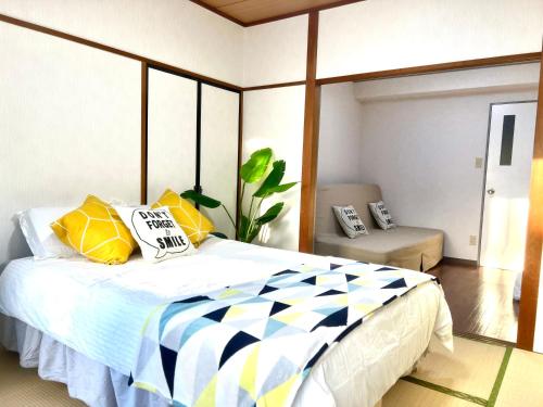 a bedroom with a bed with yellow and blue pillows at Hotel KinRin in Tokyo