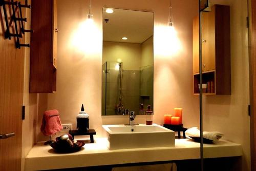 a bathroom with a sink and a mirror at Family beach apartment with lagoon view at Pico de Loro in Nasugbu