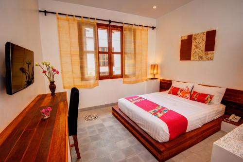 a bedroom with a large bed and a wooden table at House Boutique Eco Hotel in Phnom Penh