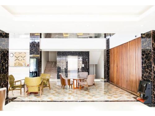 a lobby with chairs and a table in a building at Grand Palace Hotel Lusaka in Lusaka