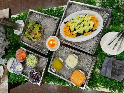 una mesa con cuatro bandejas de diferentes tipos de alimentos en Malibest Premier en Pantai Cenang