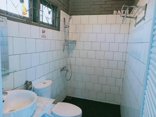 a bathroom with a toilet and a sink at Villa Forest Puncak in Tagalbato