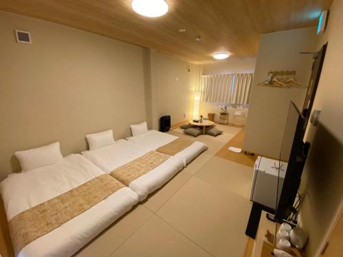 um quarto com uma cama grande num quarto em AJITO Hostel & CafeBar em Shingu