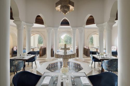 a dining room with a fountain and tables and chairs at InterContinental Durrat Al Riyadh Resort & Spa by IHG in Riyadh