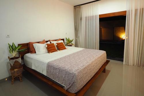 a bedroom with a large bed and a window at Umaditi Villa in Sanur