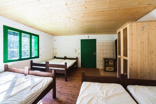 a room with three beds and a green door at Chata POUSTEVNA ( Střelecká ) in Vrbno pod Pradědem