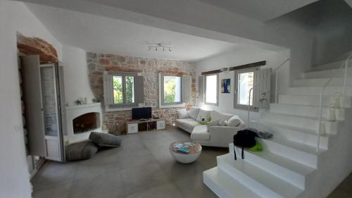 a white living room with stairs and a couch at Villa Laguna Blu in Kampos Paros