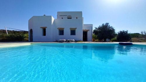 a house with a swimming pool in front of a building at Villa Laguna Blu in Kampos Paros