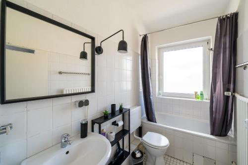 a bathroom with a sink and a toilet and a mirror at Im Herzen Hannovers 3min City 45m² 1 Zimmer Aufzug in Hannover