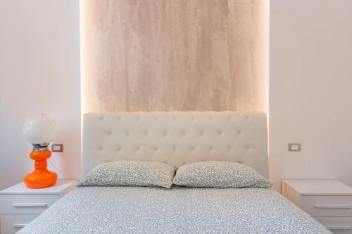um quarto com uma cama com um candeeiro laranja em 4 Gnocchi - Galbiate em Galbiate