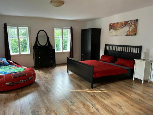 um quarto com uma cama e um edredão vermelho em Roubenka nad řekou em Noviny pod Ralskem