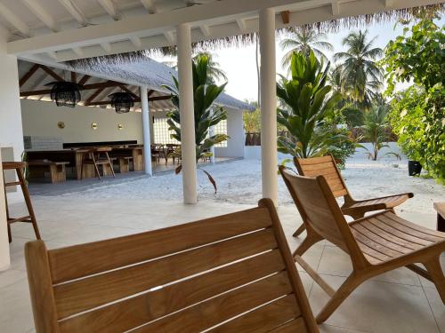 a patio with two chairs and a table on the beach at Coco Villa in Thoddoo