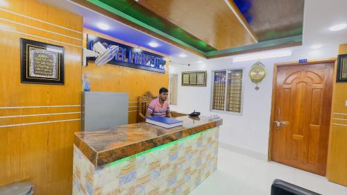 a woman sitting at a bar in a restaurant at Hotel Prime Inn Mirpur 10 in Dhaka