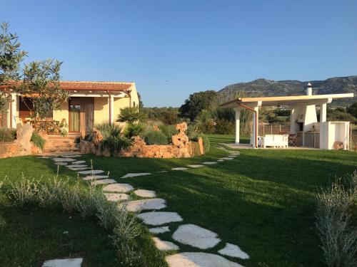 un jardín con un camino de piedra que conduce a una casa en Villa Impetrata IUN Q7090, en Orosei