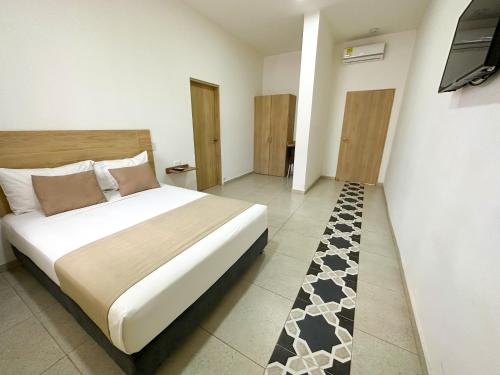 1 dormitorio con 1 cama y TV en Hotel Zamay Centro Historico, en Santa Marta