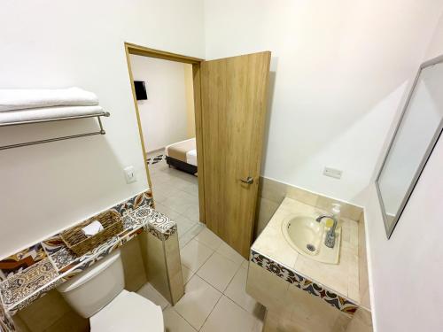 La salle de bains est pourvue de toilettes et d'un lavabo. dans l'établissement Hotel Zamay Centro Historico, à Santa Marta